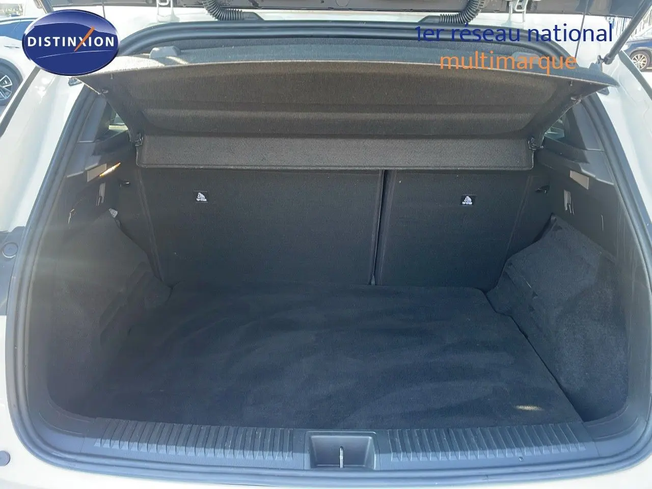 Coffre ouvert vu de l'arrière d'un Renault Austral blanc glacier, montrant un espace de chargement propre et spacieux.