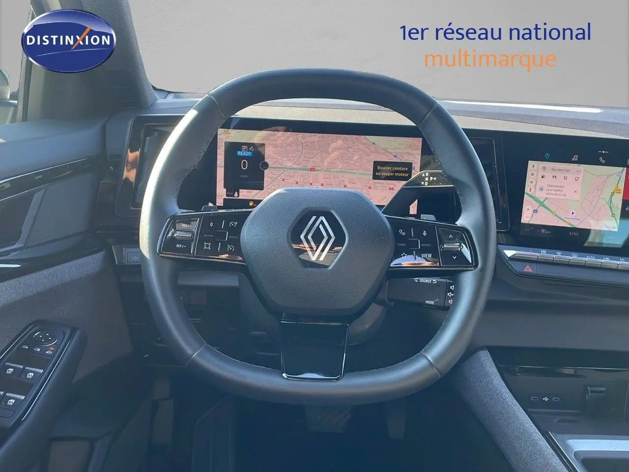 Vue intérieure centrée sur le volant noir du Renault Austral 1.2 E-Tech Hybrid 2023 avec écran tactile et navigation.