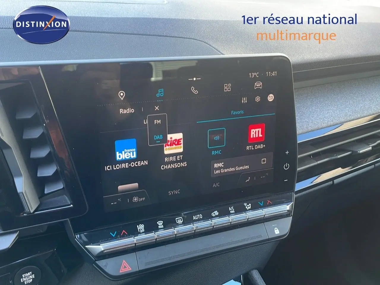 Écran tactile central du tableau de bord du Renault Austral blanc glacier, avec interface radio et commandes climatisation visibles.