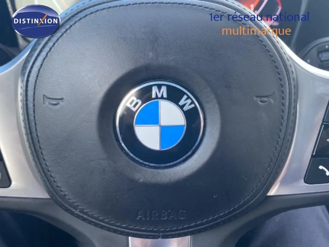 Gros plan sur le volant sport noir avec logo BMW au centre dans l’habitacle d’une Série 3 G20.