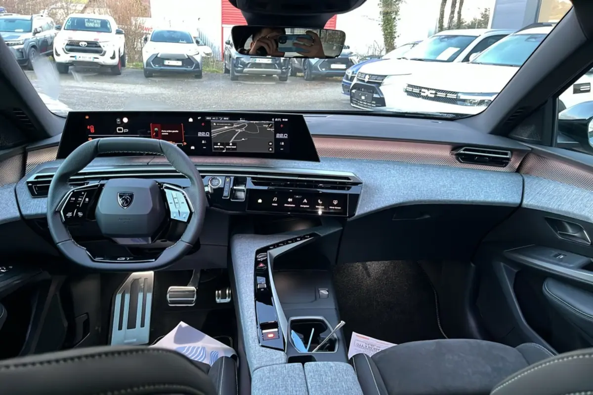 Vue intérieure du tableau de bord et volant cuir multifonctions du Peugeot 5008 Hybrid 145 GT Alcantara 2025.