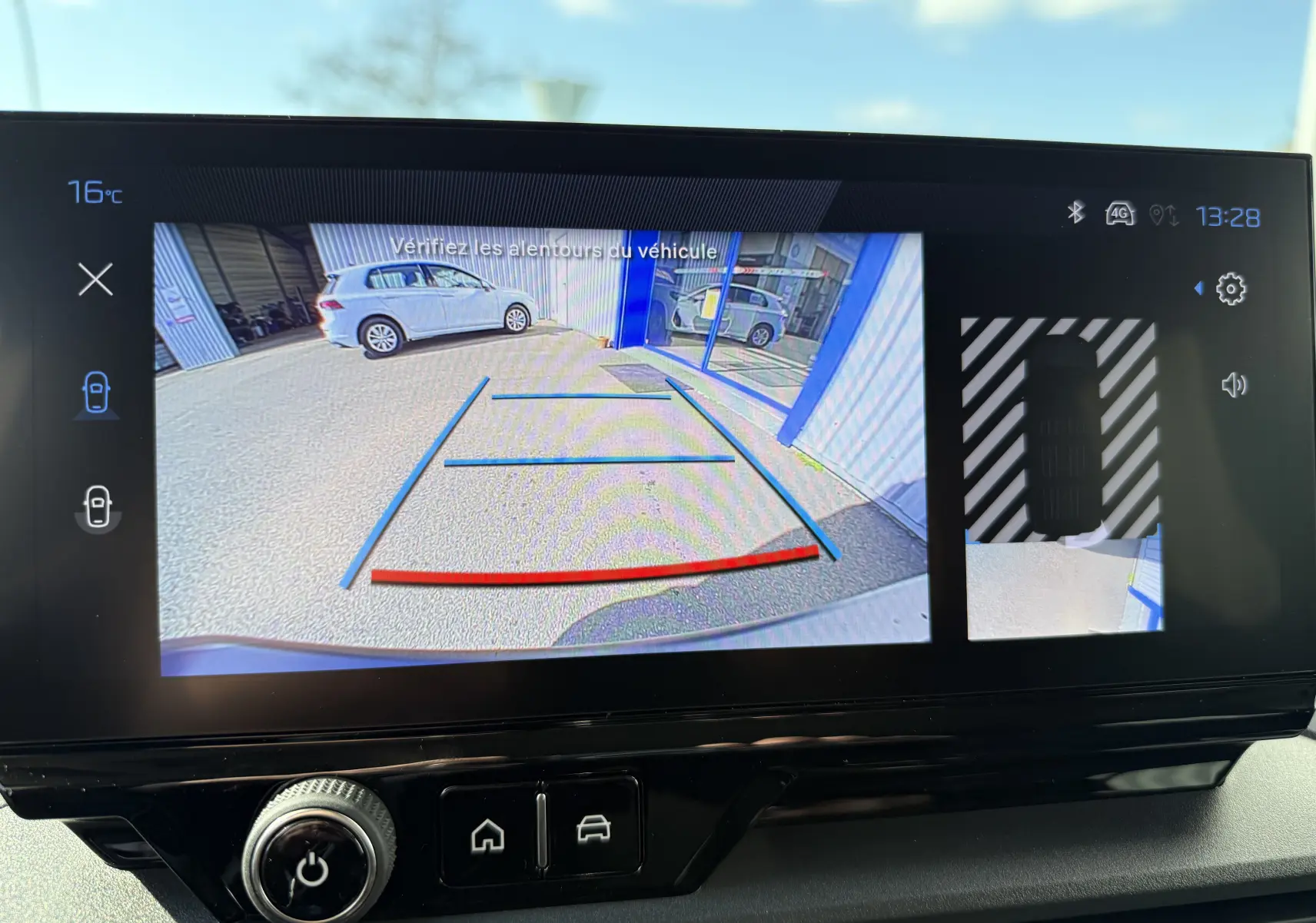 Écran de caméra de recul du Peugeot Rifter noir Perla Nera montrant l’arrière avec lignes de guidage et vue latérale droite.