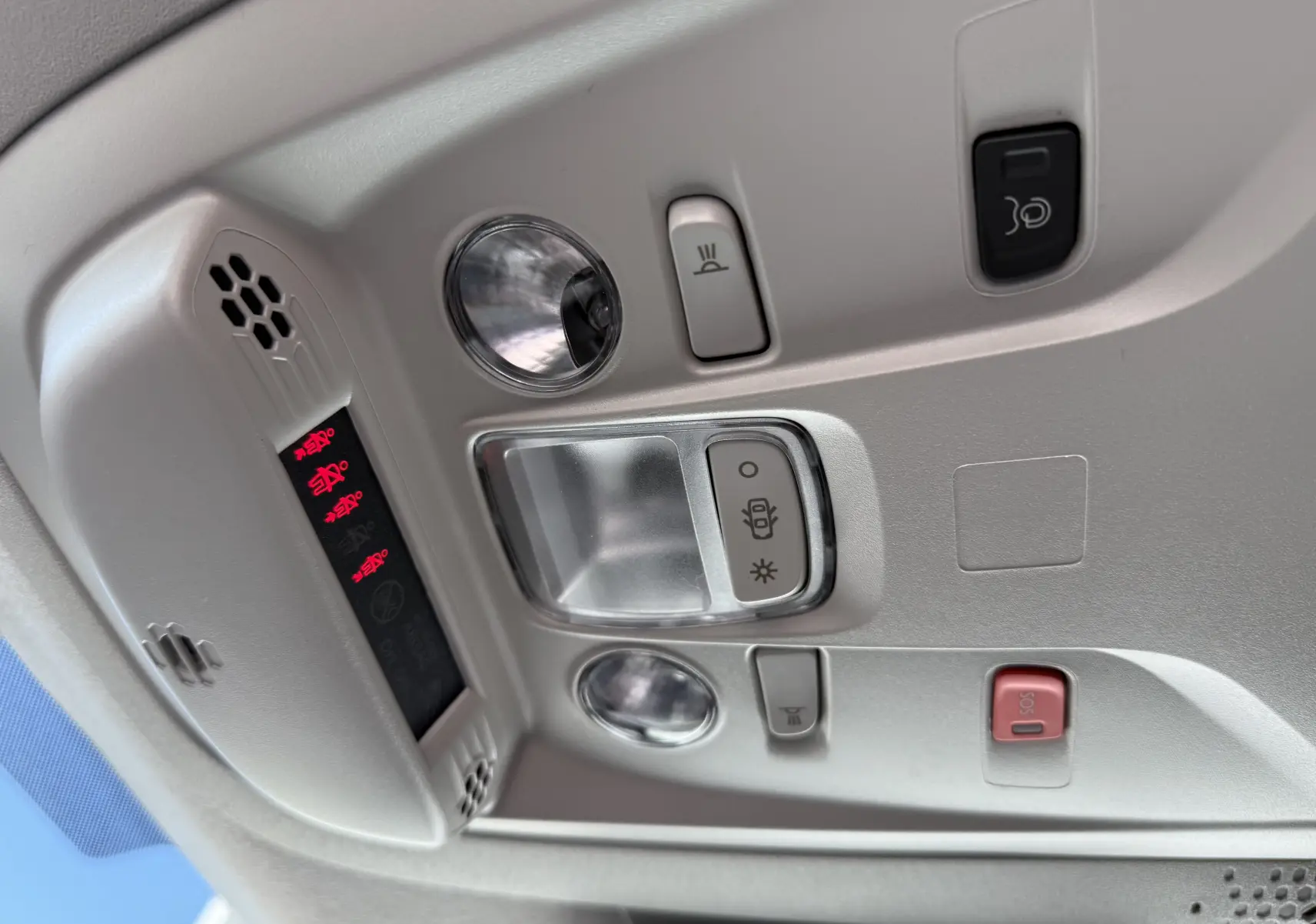 Plafonnier intérieur gris clair du Peugeot Rifter Allure 2026 avec boutons d’éclairage et alerte SOS visibles.