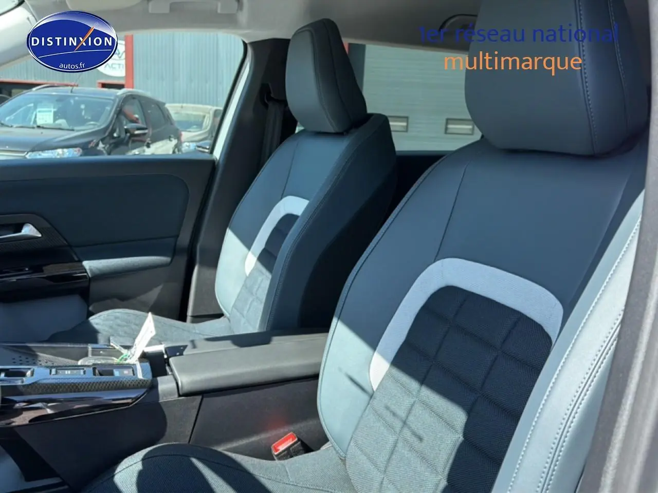 Vue intérieure côté droit montrant les sièges avant gris et noirs du Citroën C5 Aircross hybride 2026 avec accoudoir central.