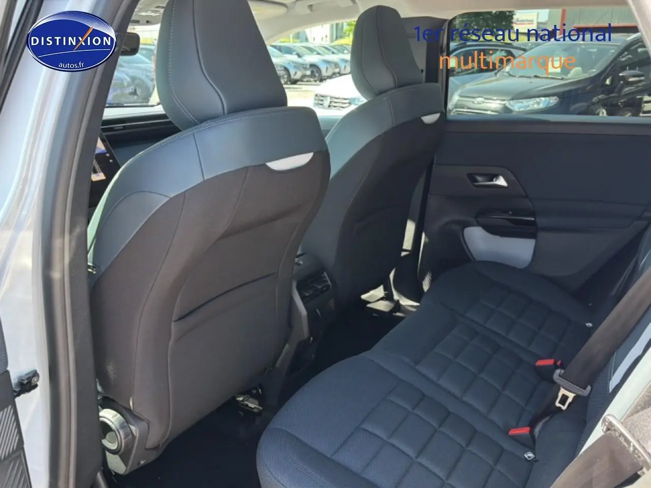 Vue arrière côté gauche de l'intérieur du Citroën C5 Aircross 2026 blanc/noir, montrant la banquette arrière et les dossiers avant.