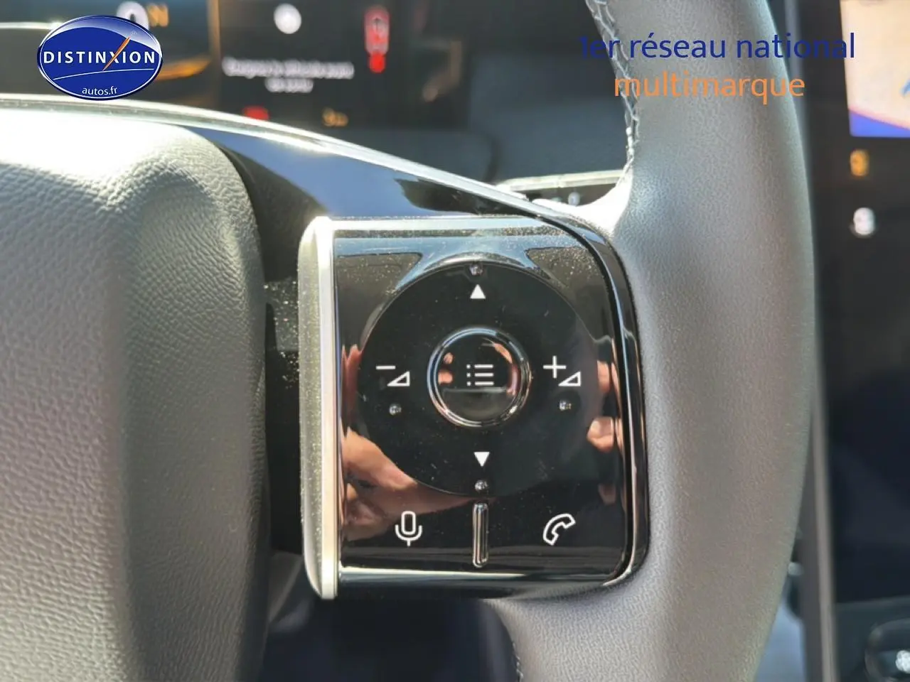 Gros plan sur les commandes multifonctions du volant gris clair du Citroën C5 Aircross hybride blanc et noir.