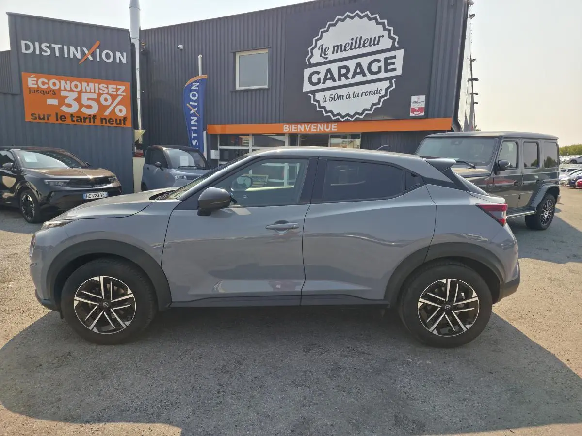 Nissan Juke gris métallisé vue de profil côté gauche, avec jantes alliage 17 pouces et vitres teintées.