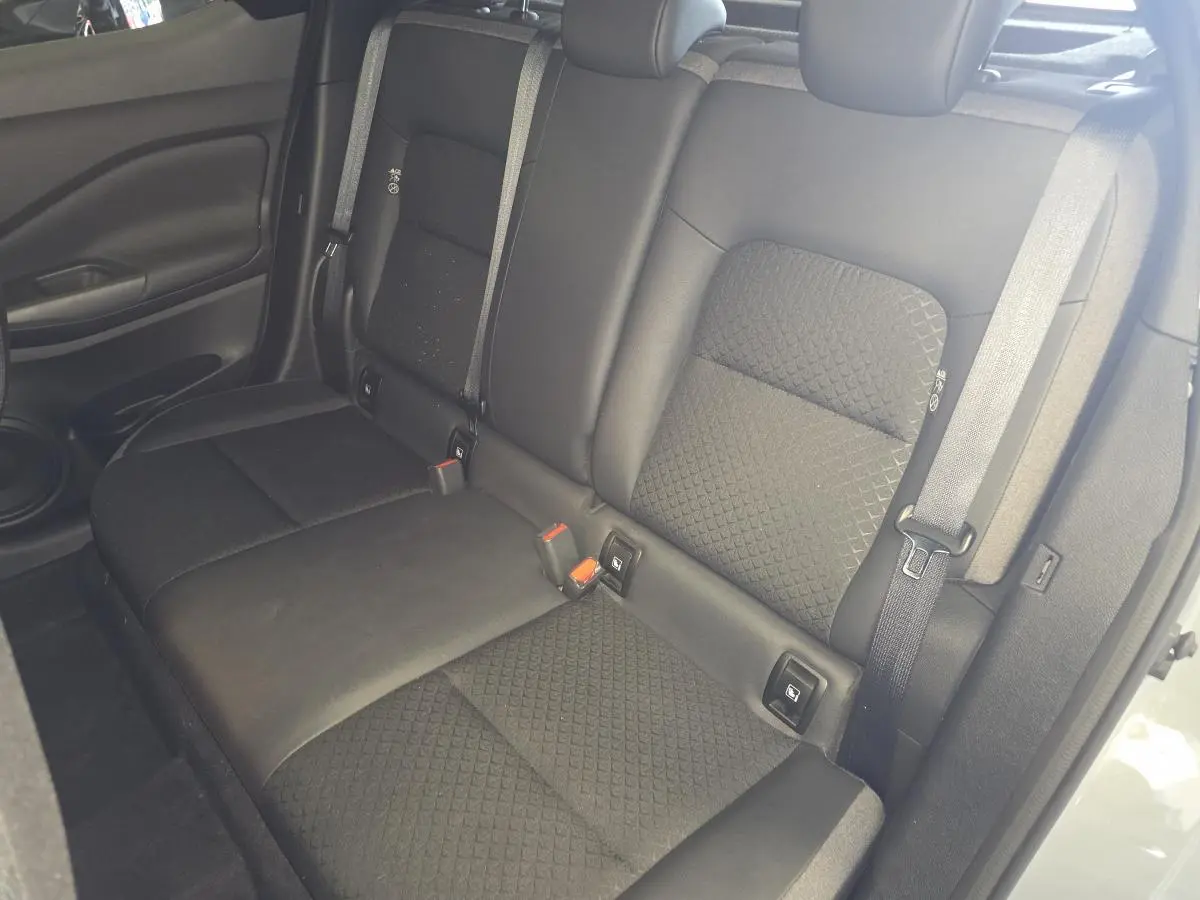Vue intérieure sur la banquette arrière noire mixte TEP/tissu du Nissan Juke 2025 avec ceintures et appuis-tête réglables.