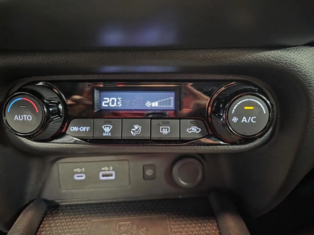Panneau de commande de climatisation automatique du Nissan Juke 2025, avec affichage digital et boutons noirs.