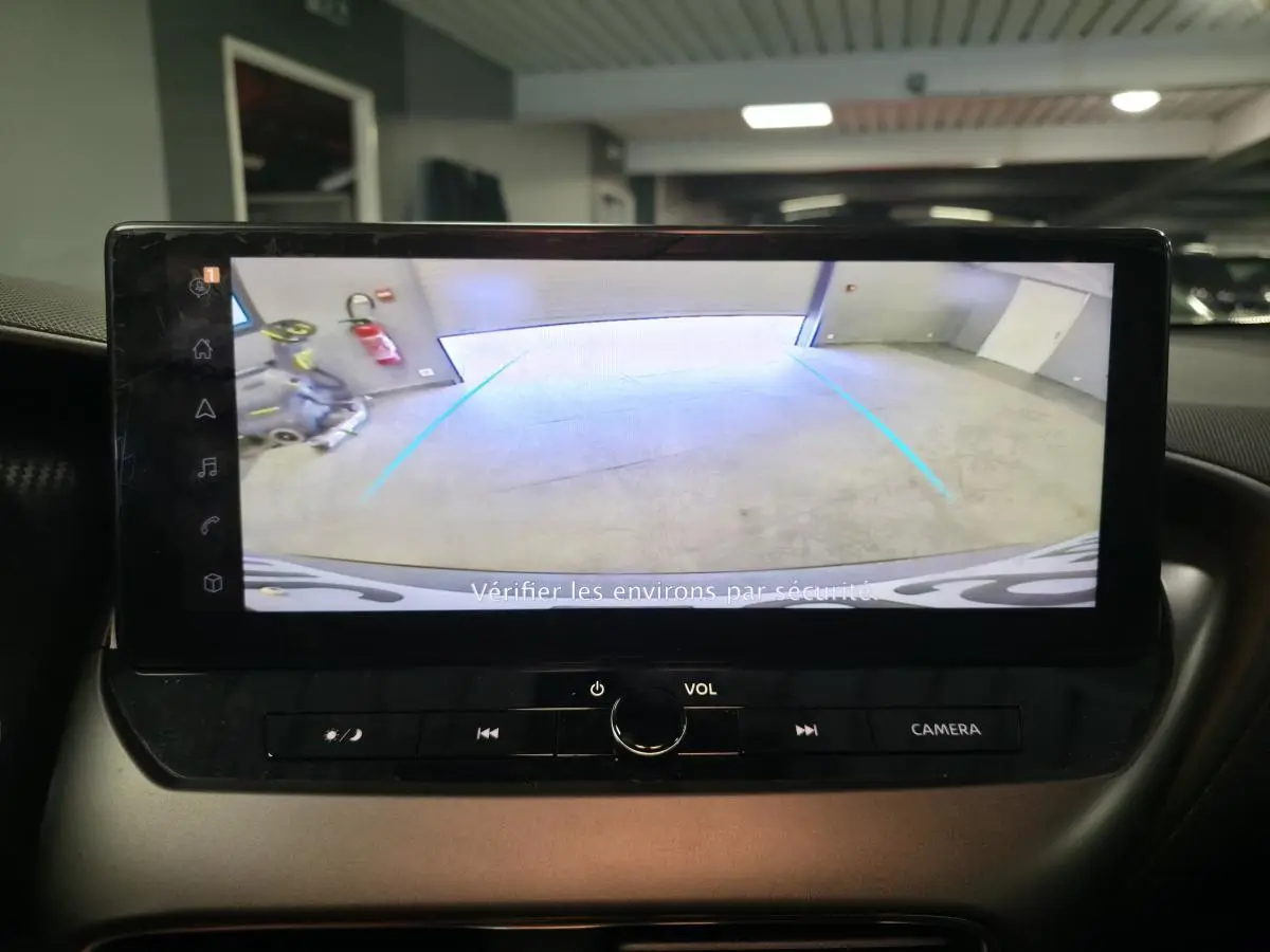 Écran tactile intérieur du Nissan Juke 2025 affichant la caméra de recul avec lignes d’aide au stationnement.