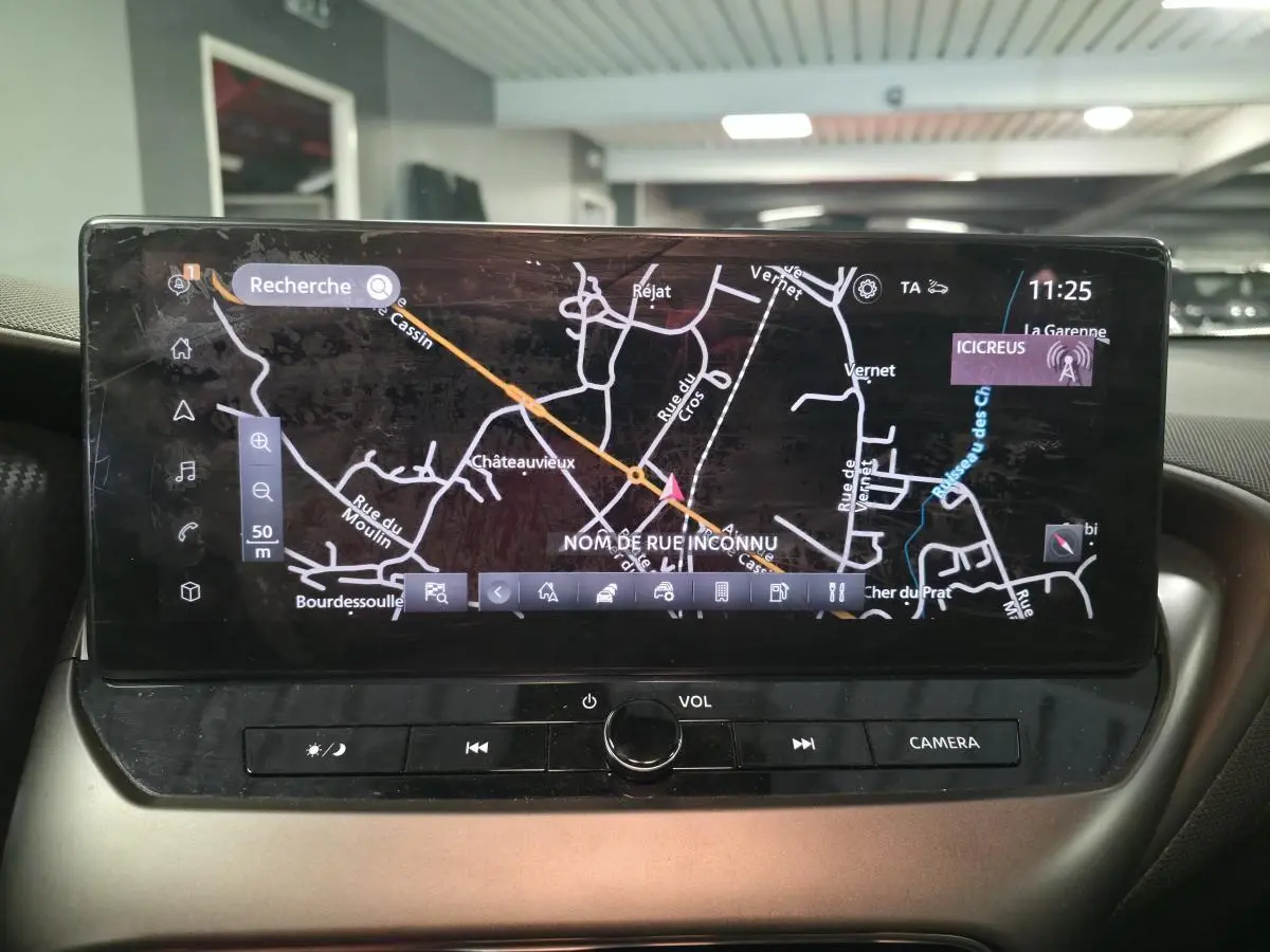 Écran tactile central du Nissan Juke 2025 affichant la navigation avec carte et commandes multimédia en vue rapprochée.