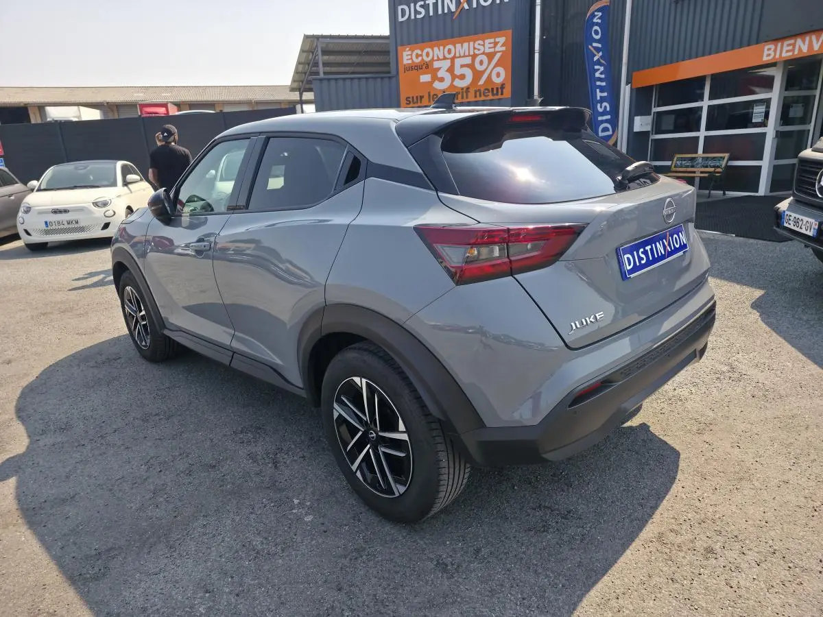 Nissan Juke gris métallisé vue 3/4 arrière droit, jantes alliage 17'', toit noir et feux arrière LED.