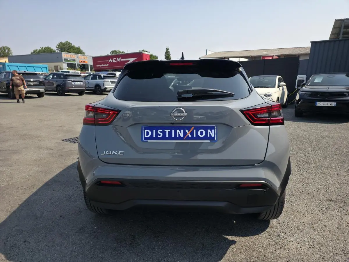 Vue arrière d'un Nissan Juke gris métallisé 2025 avec feux LED et antenne aileron de requin noire.