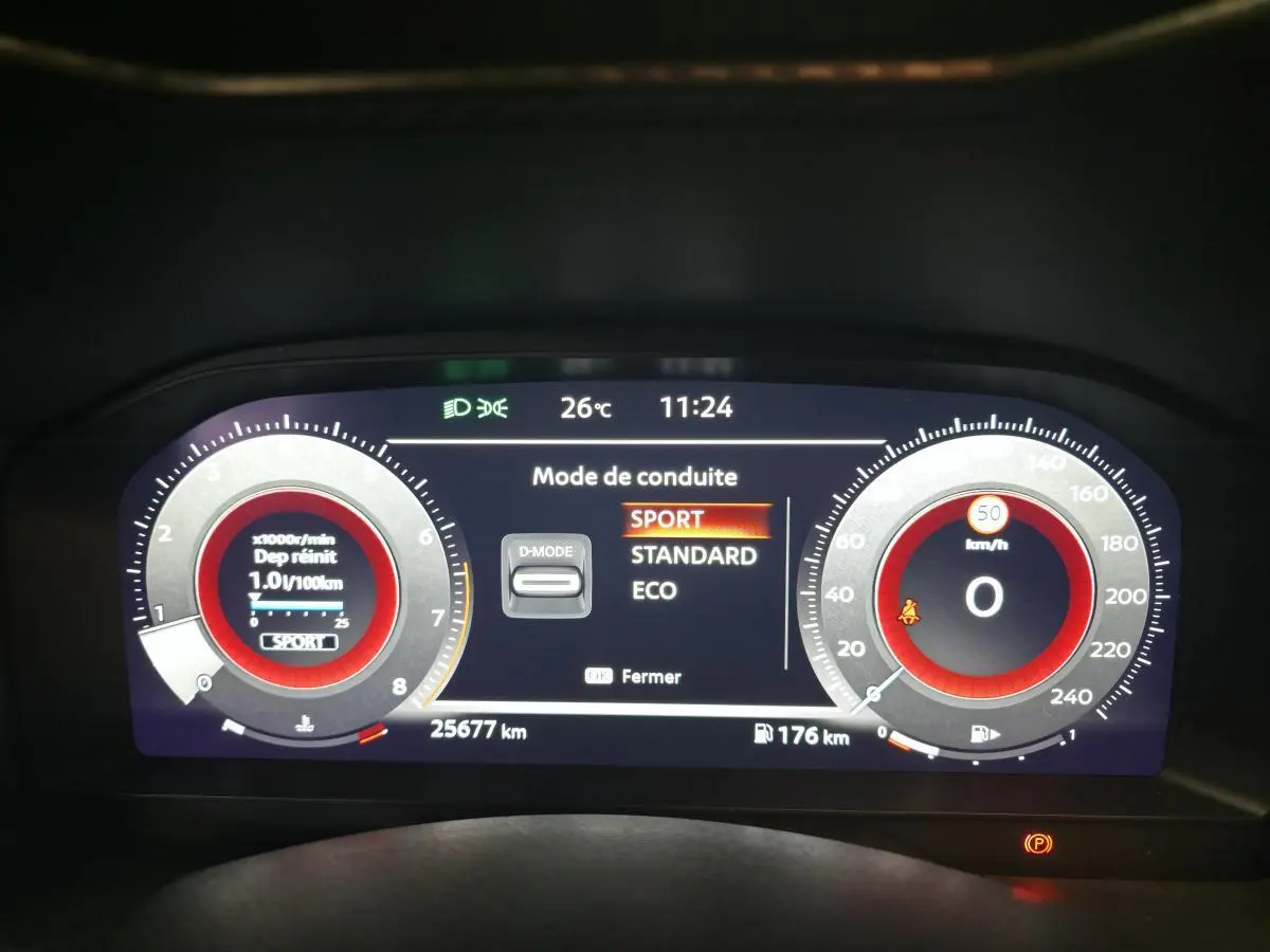 Tableau de bord digital du Nissan Juke 2025 affichant le mode de conduite Sport en vue frontale.