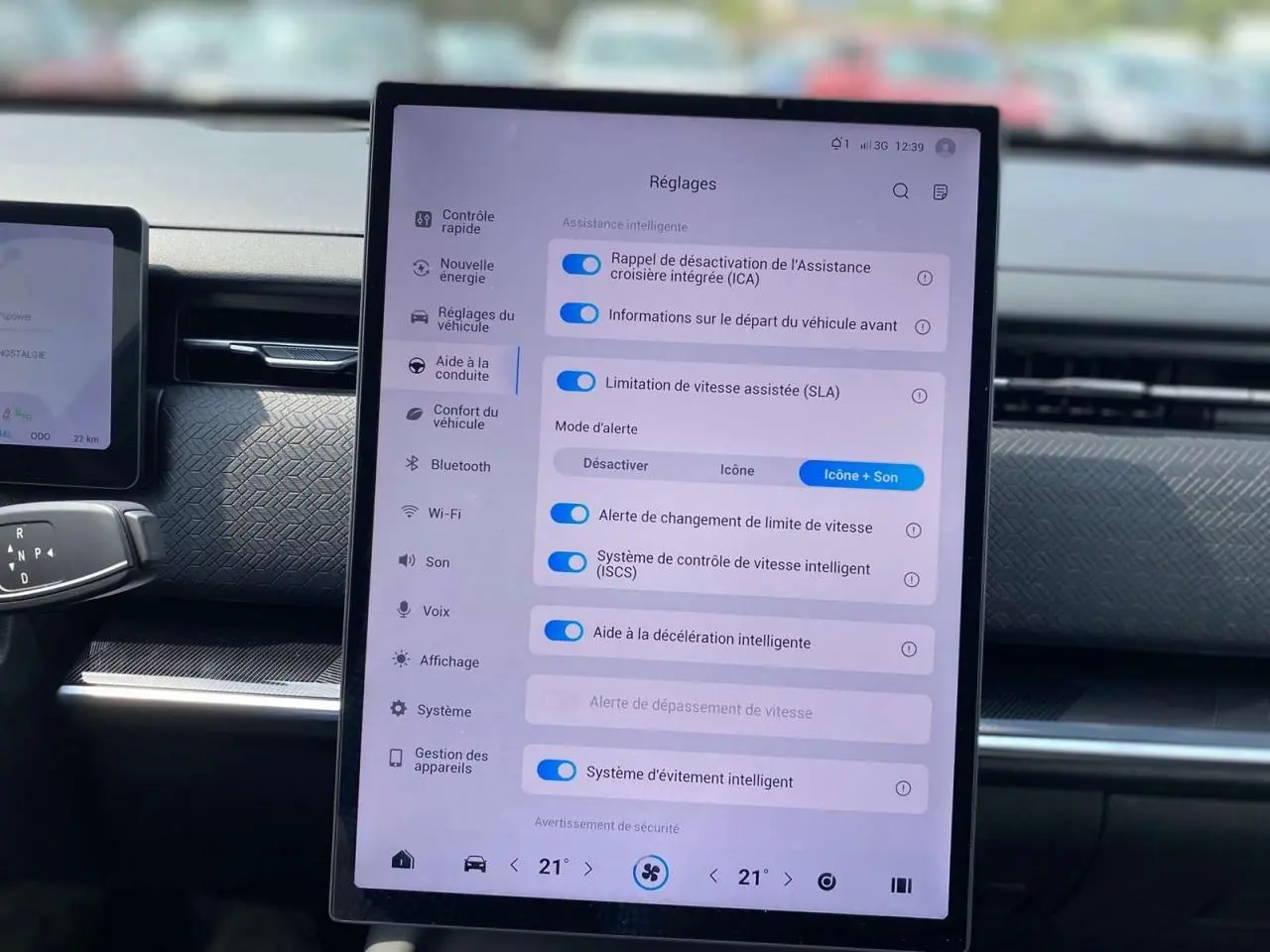 Vue intérieure centrée sur l'écran tactile des réglages d'assistance du SUV JAECOO J7 blanc khaki 2026.