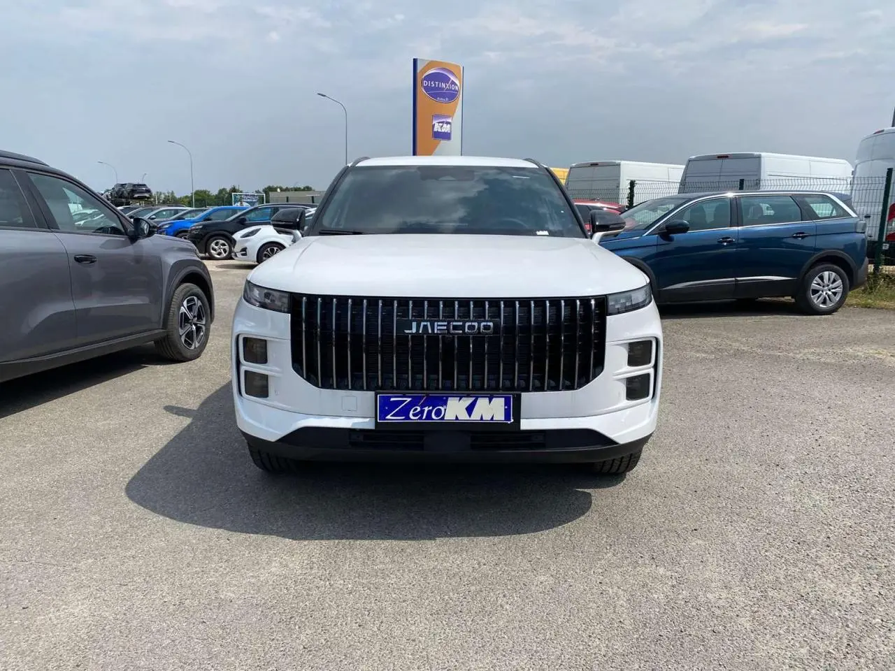 Vue frontale du SUV JAECOO J7 blanc khaki 2026 avec calandre verticale noire et plaque d’immatriculation Zero KM.
