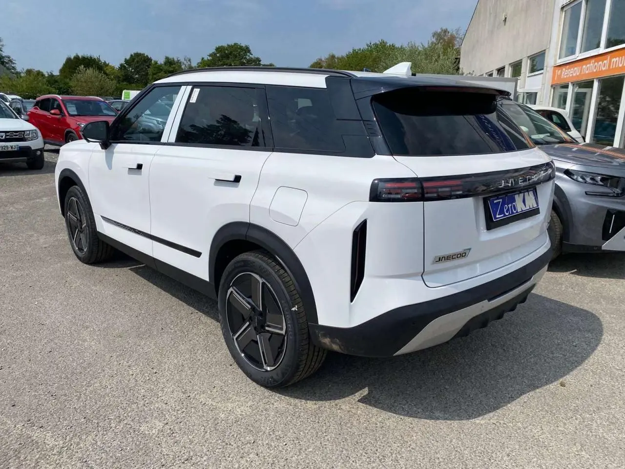 SUV JAECOO J7 blanc khaki vu en 3/4 arrière droit, avec toit noir et feux arrière horizontaux fins.