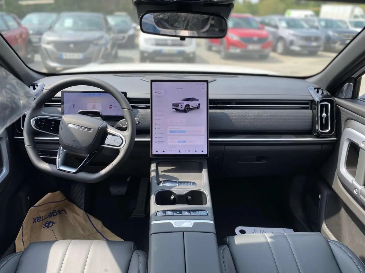 Vue intérieure avant du SUV JAECOO J7 2026, avec tableau de bord moderne, écran tactile vertical et volant multifonction.