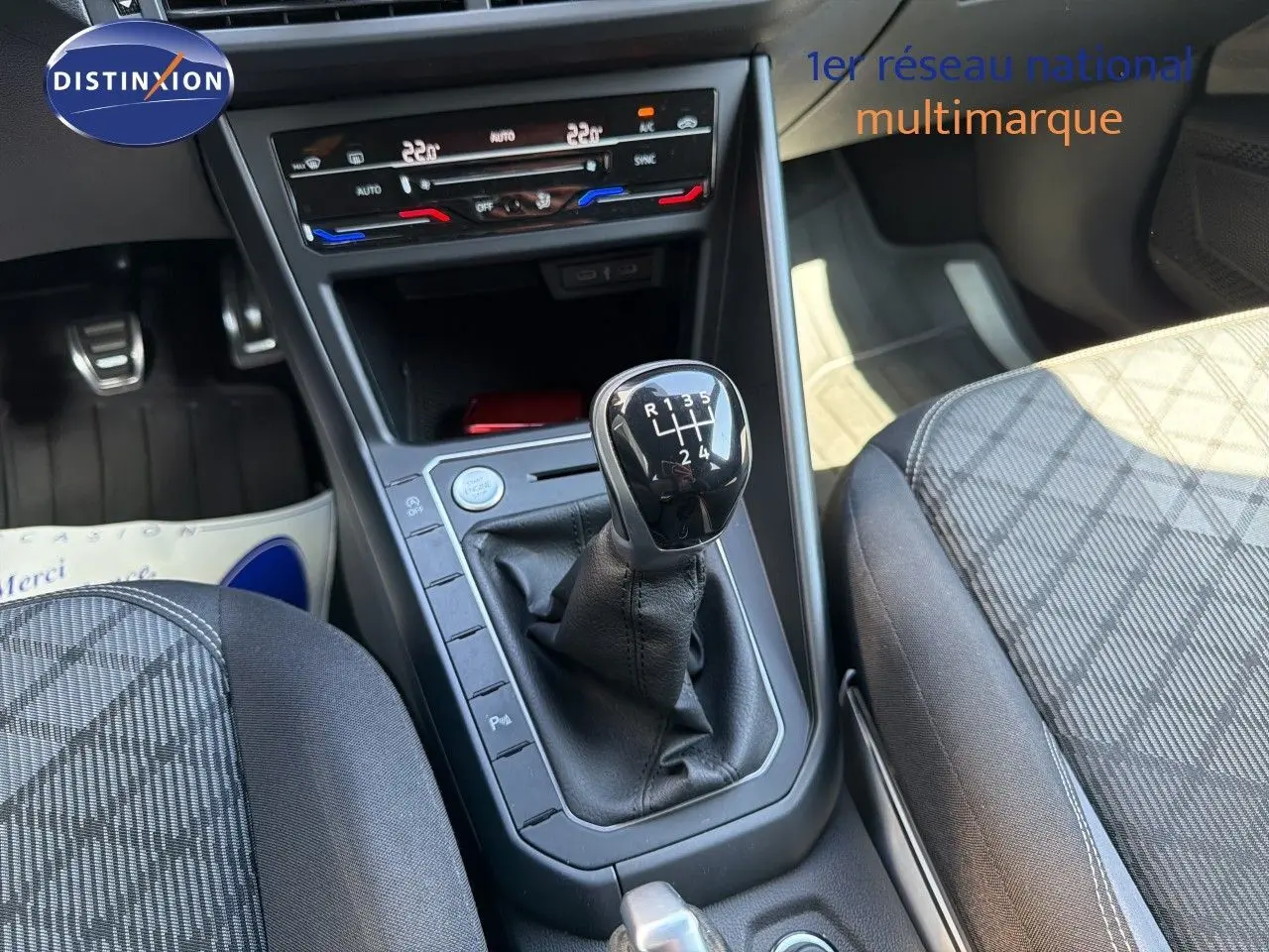 Gros plan sur la console centrale d'une Volkswagen Polo rouge Roi 2023, mettant en valeur le levier de vitesses manuel.