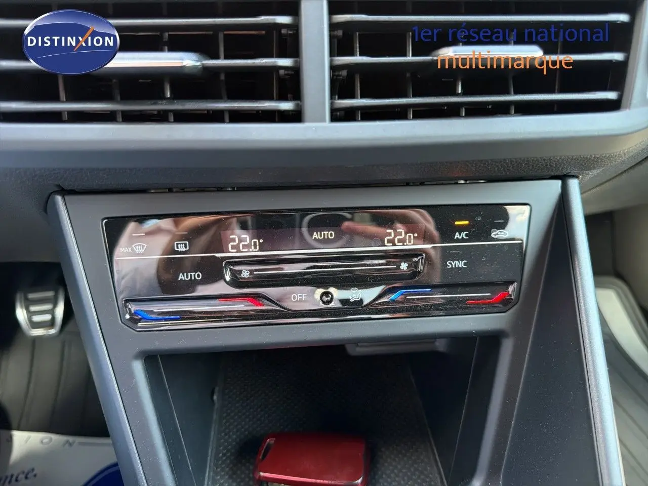 Vue rapprochée du tableau de bord de la Volkswagen Polo rouge Roi 2023, avec commandes de climatisation digitales.