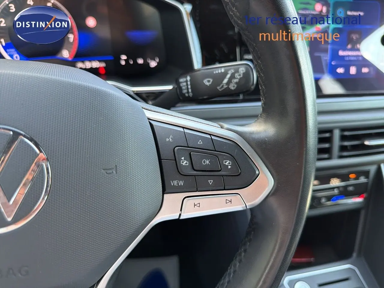Gros plan sur le volant multifonction noir et argenté de la Volkswagen Polo 2023, avec tableau de bord numérique en arrière-plan.