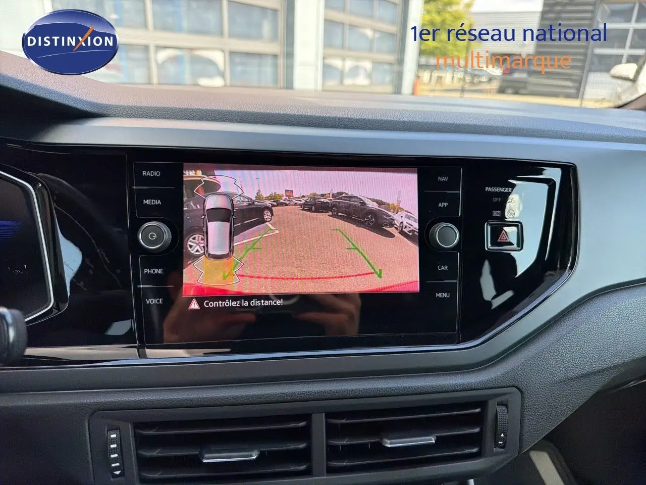 Vue intérieure du tableau de bord de la Volkswagen Polo rouge Roi 2023 avec écran de caméra de recul allumé.