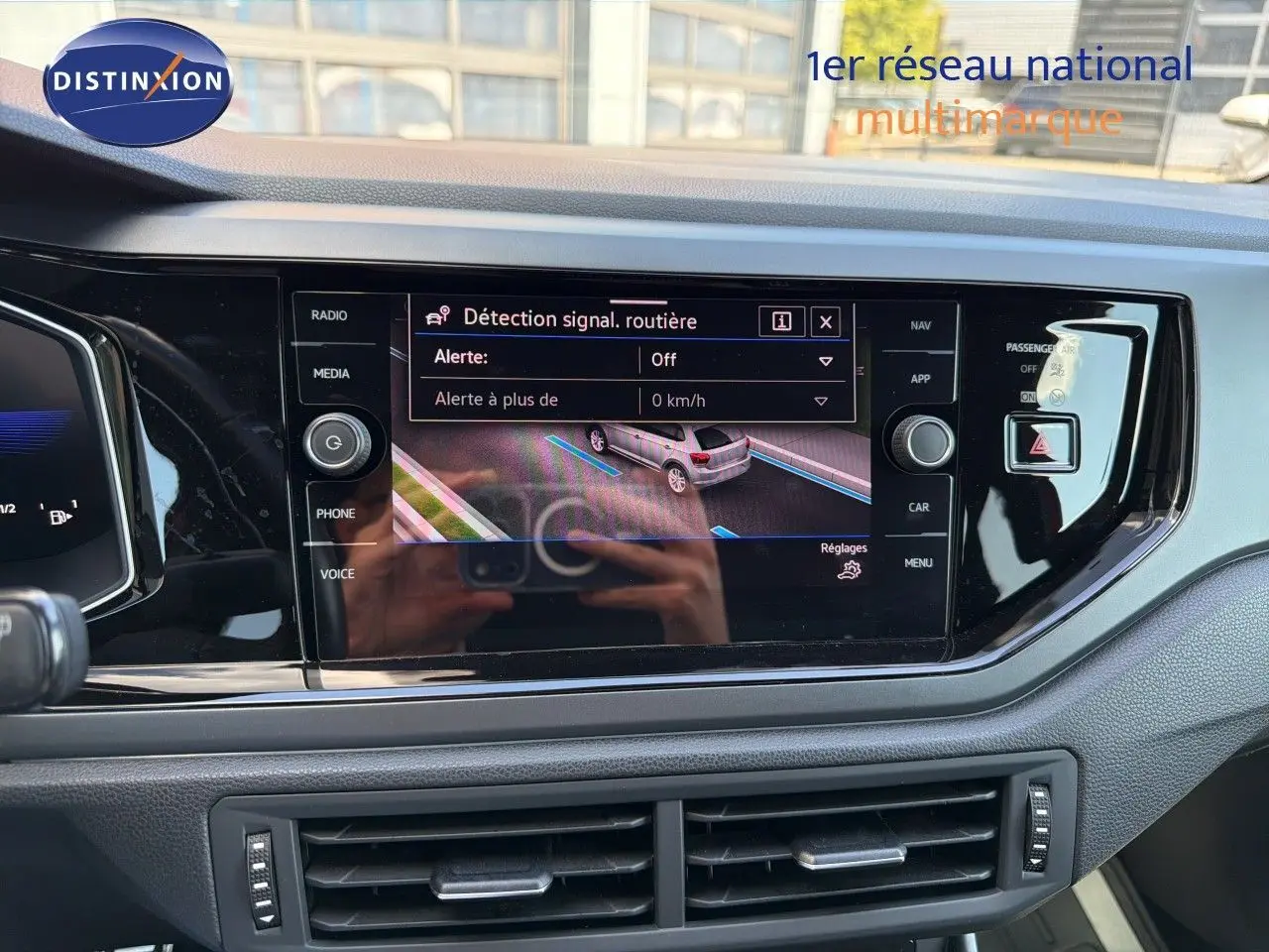 Vue rapprochée de l’écran tactile central de la Volkswagen Polo rouge Roi 2023, affichant le régulateur de distance ACC.