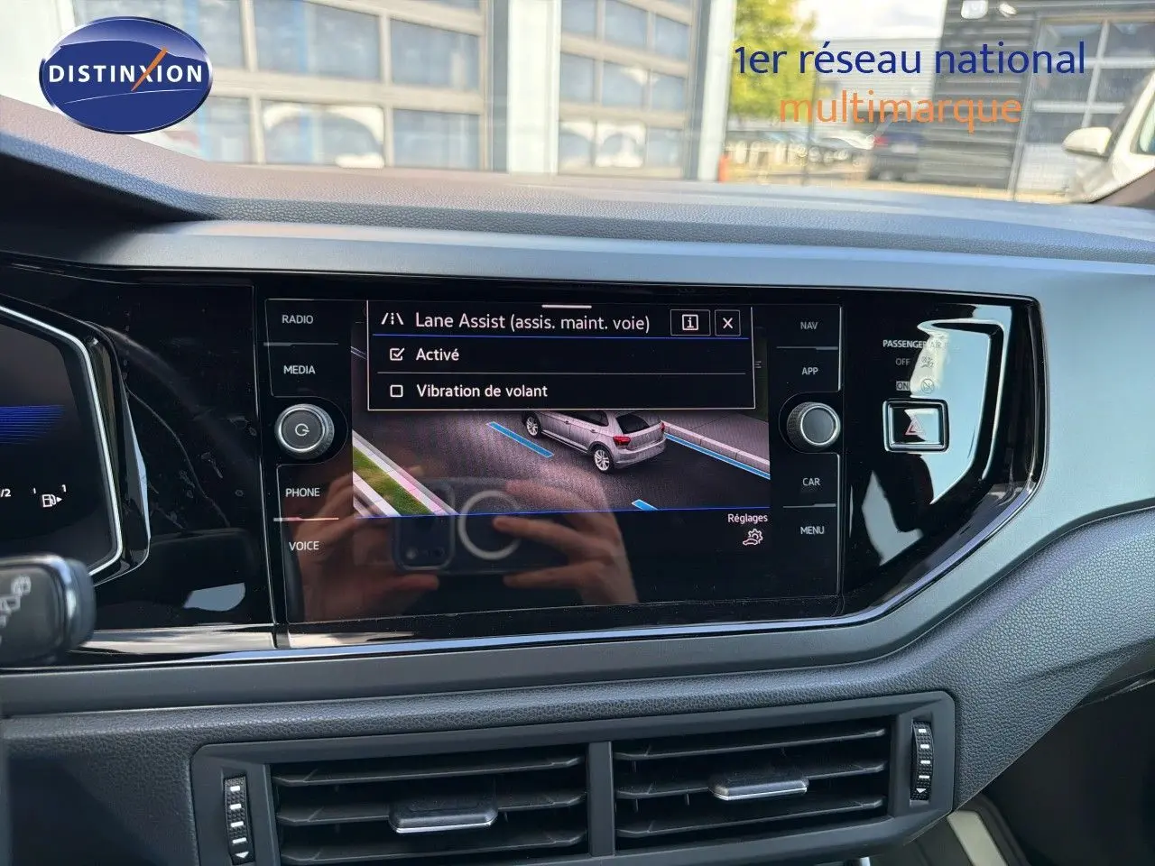 Vue intérieure centrée sur l'écran tactile du tableau de bord de la Volkswagen Polo 2023 avec affichage du Lane Assist.
