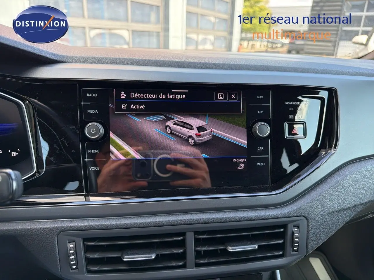 Vue rapprochée de l’écran central tactile du tableau de bord d’une Volkswagen Polo rouge Roi 2023 avec interface active.