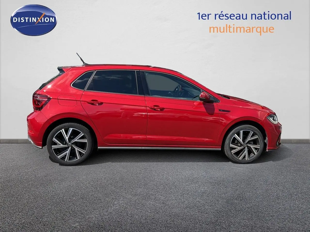 Profil droit d'une Volkswagen Polo rouge roi 2023 finition R-Line avec jantes alliage bicolores.
