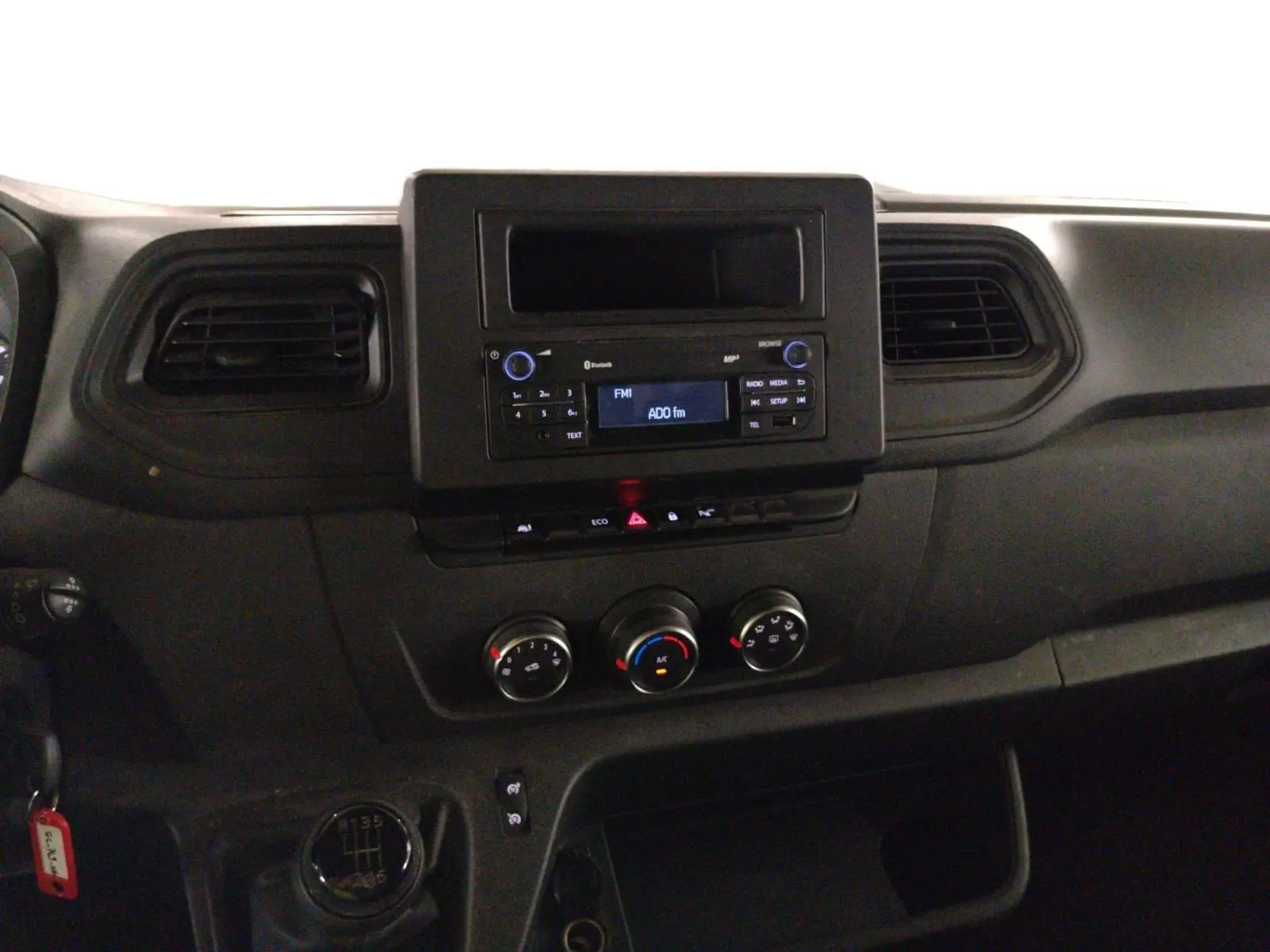 Vue intérieure du tableau de bord du Renault Master 2023, avec console centrale noire et commandes de climatisation visibles.