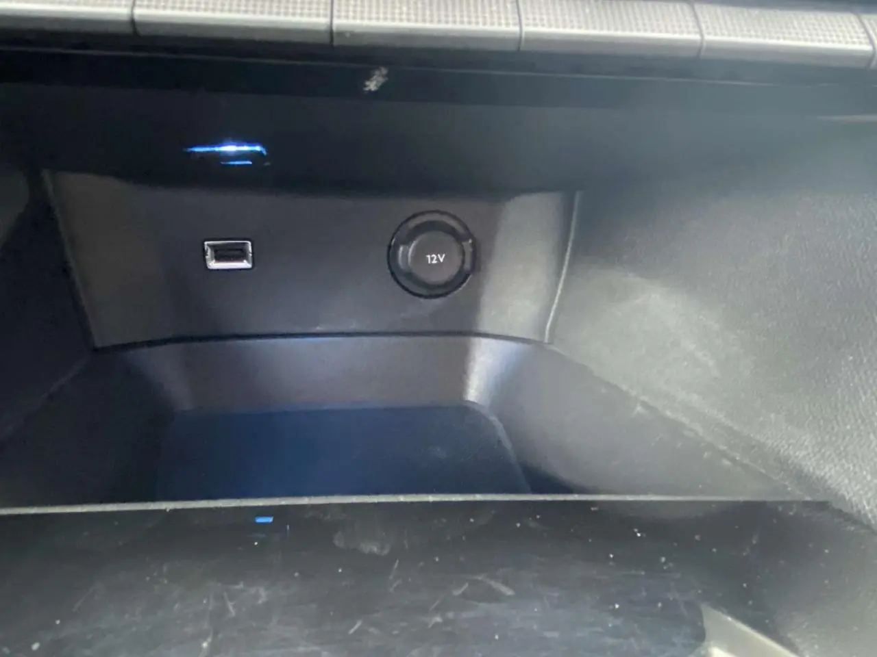 Prise USB et prise 12V en gros plan dans le compartiment de la Peugeot 3008 blanche, version Allure 2017.
