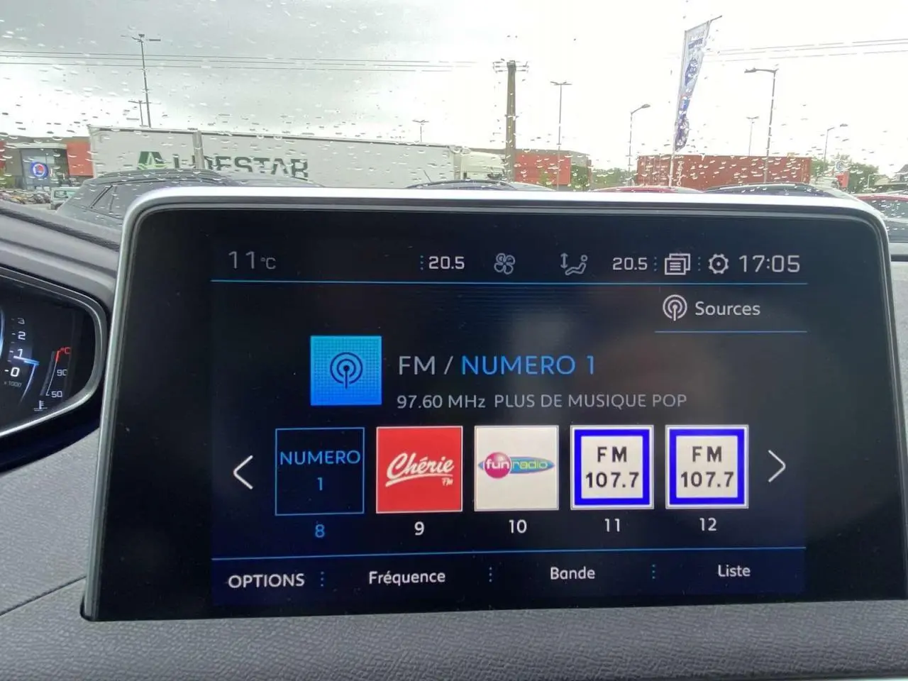 Vue intérieure du tableau de bord du Peugeot 3008 blanc 2017, écran tactile multimédia affichant les stations radio FM.