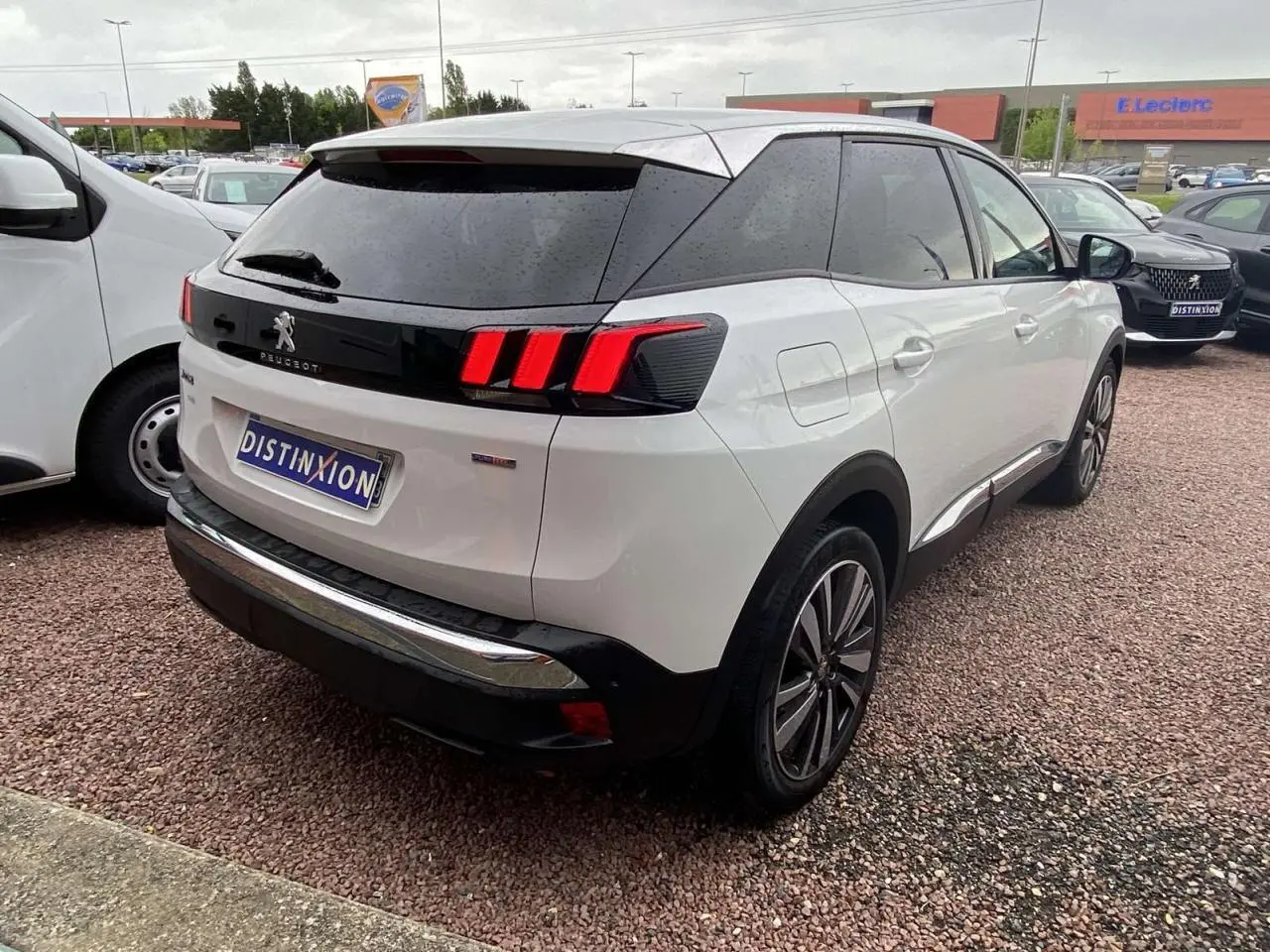 Vue 3/4 arrière droite d'un Peugeot 3008 blanc nacré avec vitres surteintées et jantes alliage 19 pouces Washington.