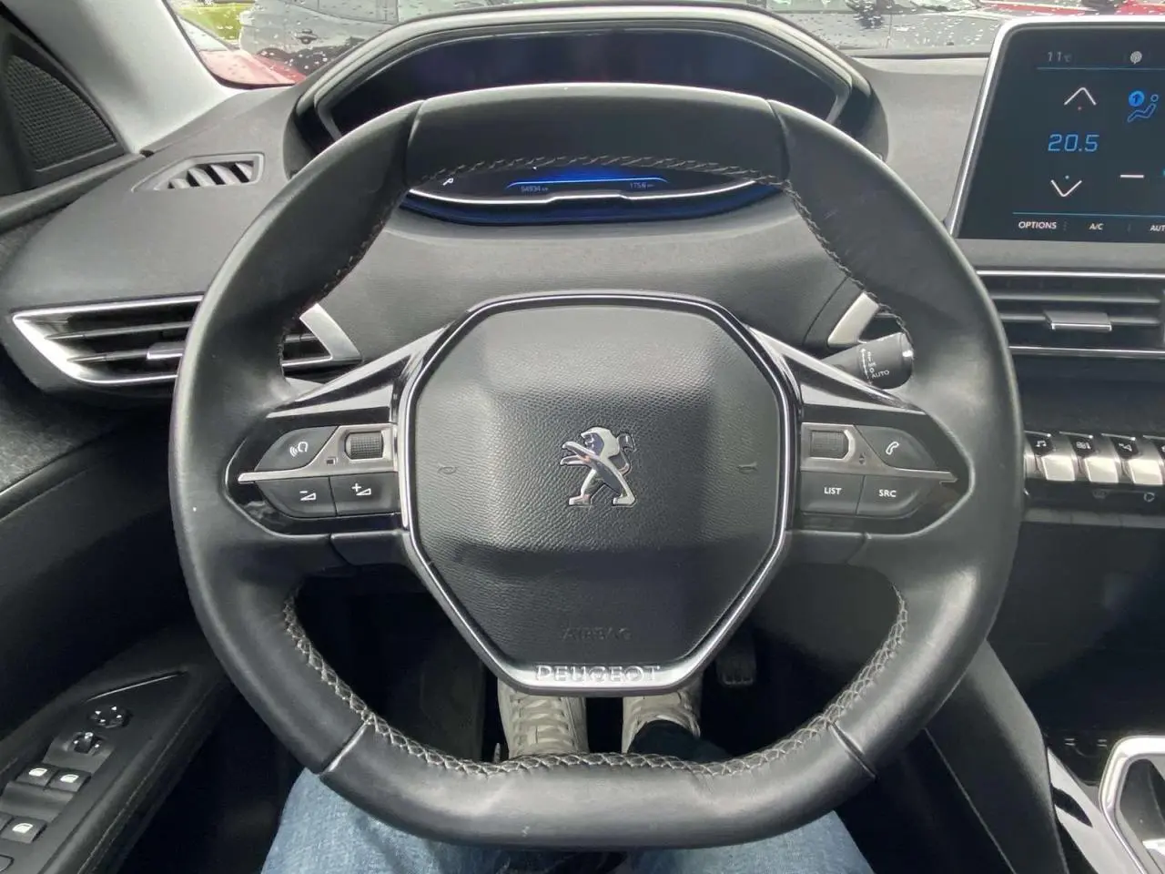 Vue rapprochée du volant compact noir du Peugeot 3008 2017 avec tableau de bord numérique et écran tactile.