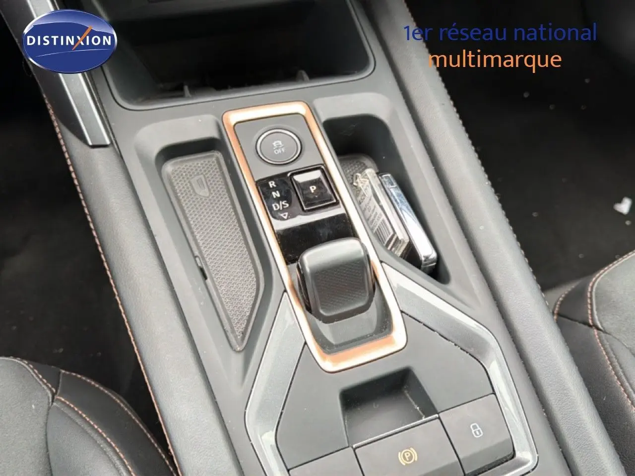 Gros plan sur la console centrale avec levier de vitesses automatique et finitions cuivrées du CUPRA Formentor blanc neige 2025.