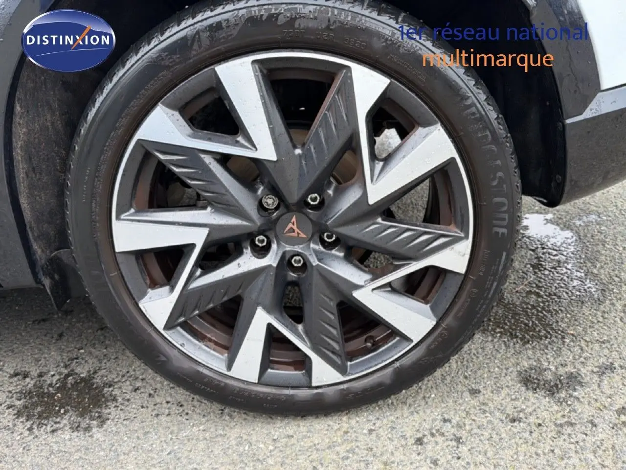 Gros plan sur la jante bi-ton gris et argentée du côté avant droit d'une CUPRA Formentor blanc neige métal.