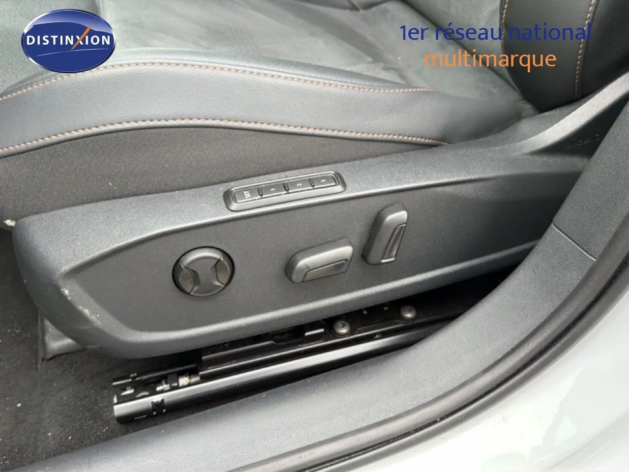 Gros plan sur les commandes électriques du siège conducteur en cuir noir de la CUPRA Formentor blanc neige métal.