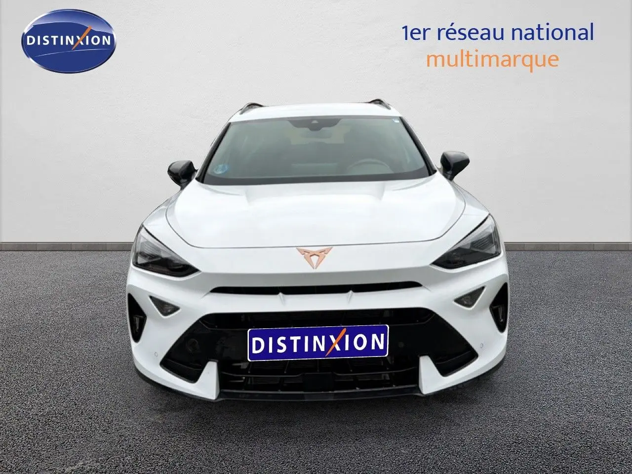 Vue frontale d'un CUPRA Formentor blanc neige métal avec calandre noire et logo cuivré bien visible.