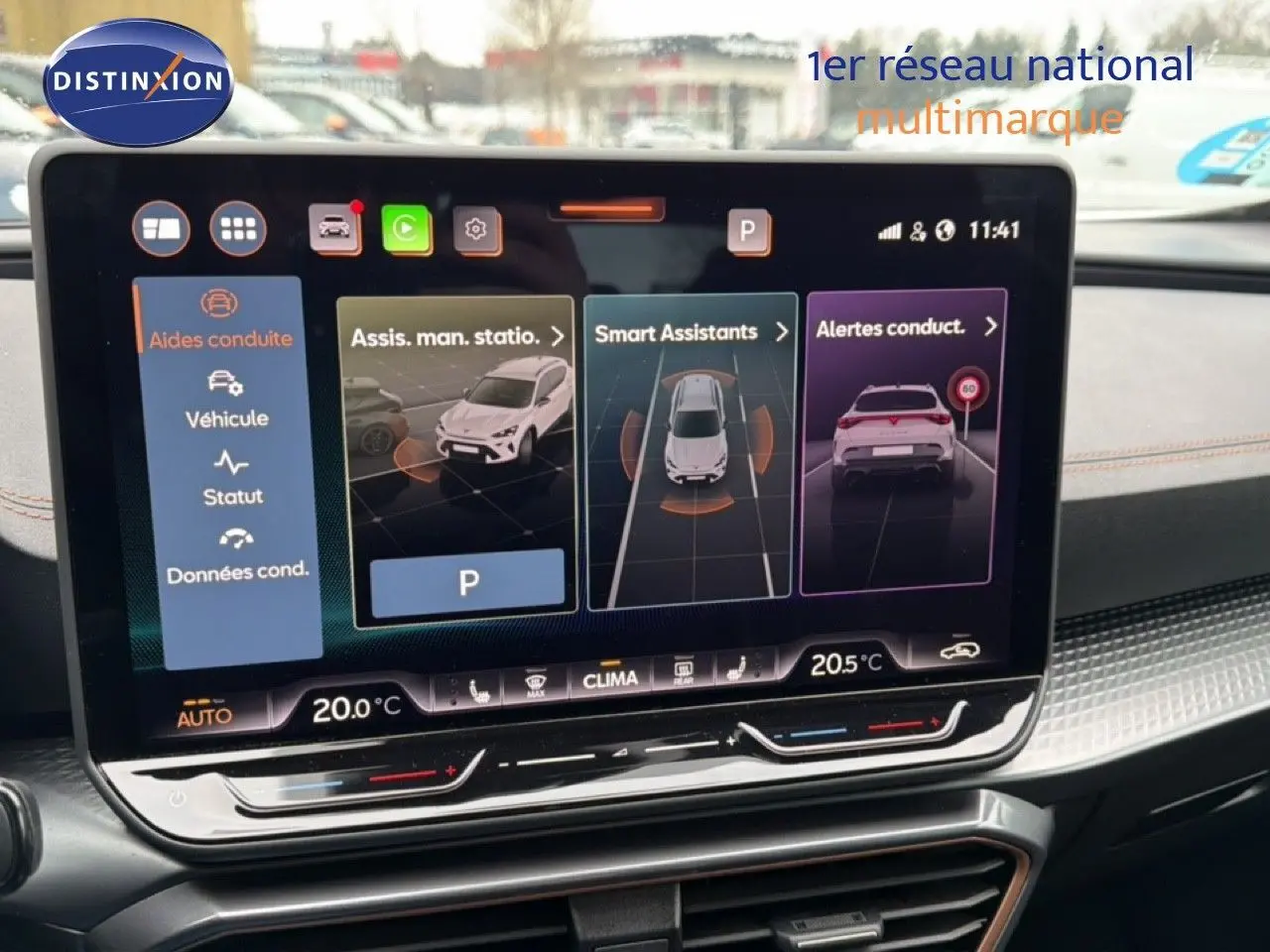 Vue rapprochée de l'écran tactile du tableau de bord du CUPRA Formentor blanc neige métal, affichant les aides à la conduite.