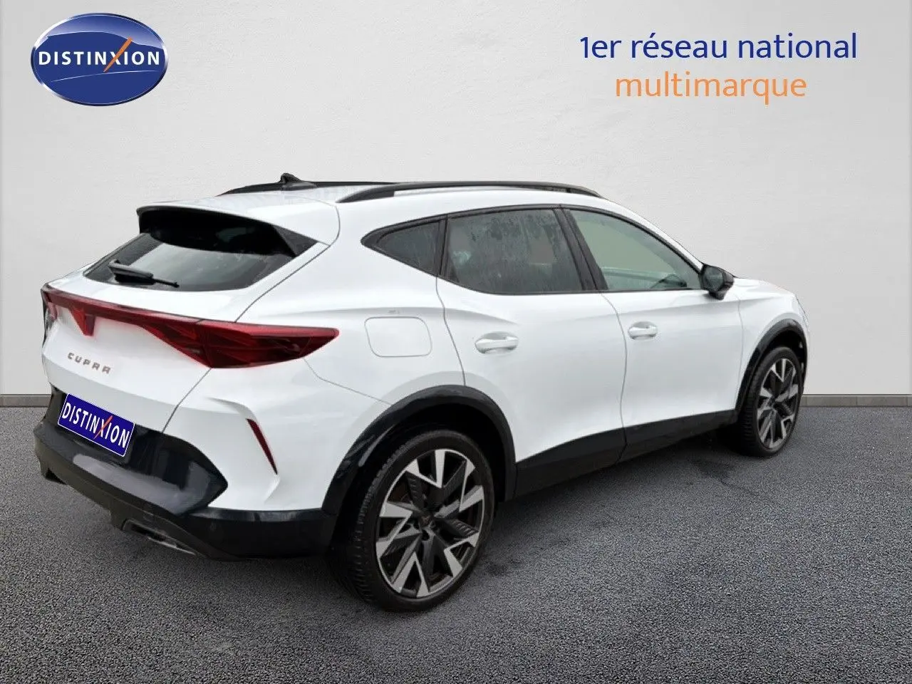 Vue 3/4 arrière droit d'un CUPRA Formentor blanc neige métal avec jantes bi-ton et détails noirs contrastants.