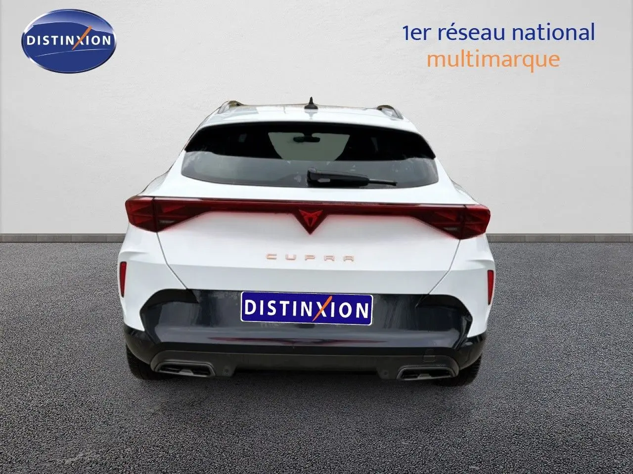 Vue arrière d'une CUPRA Formentor blanc neige métal 2025 avec feux arrière reliés et double sortie d'échappement intégrée.