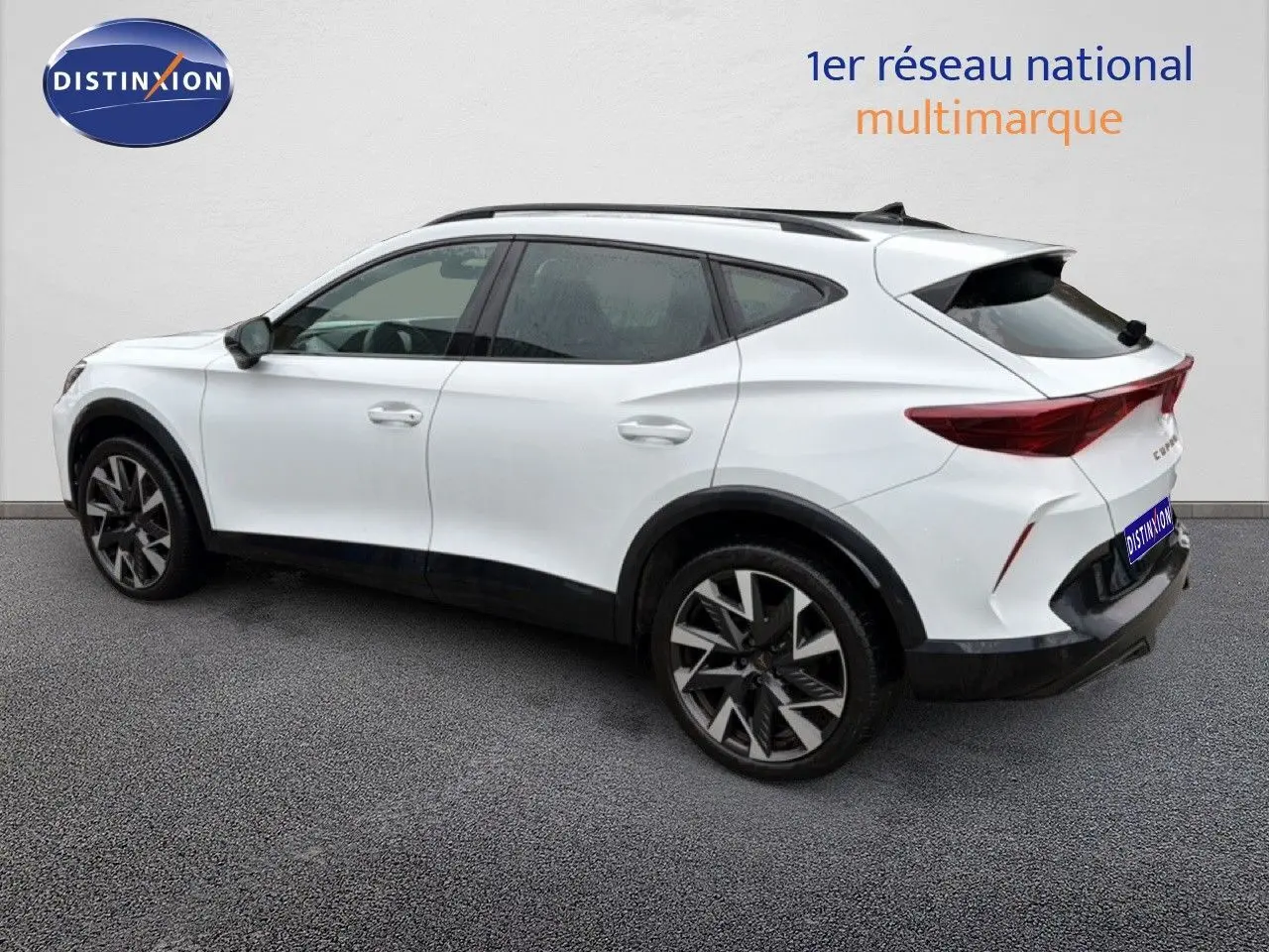 Vue 3/4 arrière droite d’un CUPRA Formentor blanc neige métal avec jantes noires et toit ouvrant.