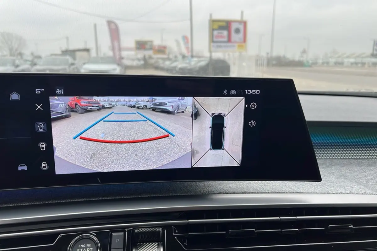 Écran intérieur affichant la caméra de recul et vue 360° du Peugeot 5008 hybride gris artense avec toit noir.