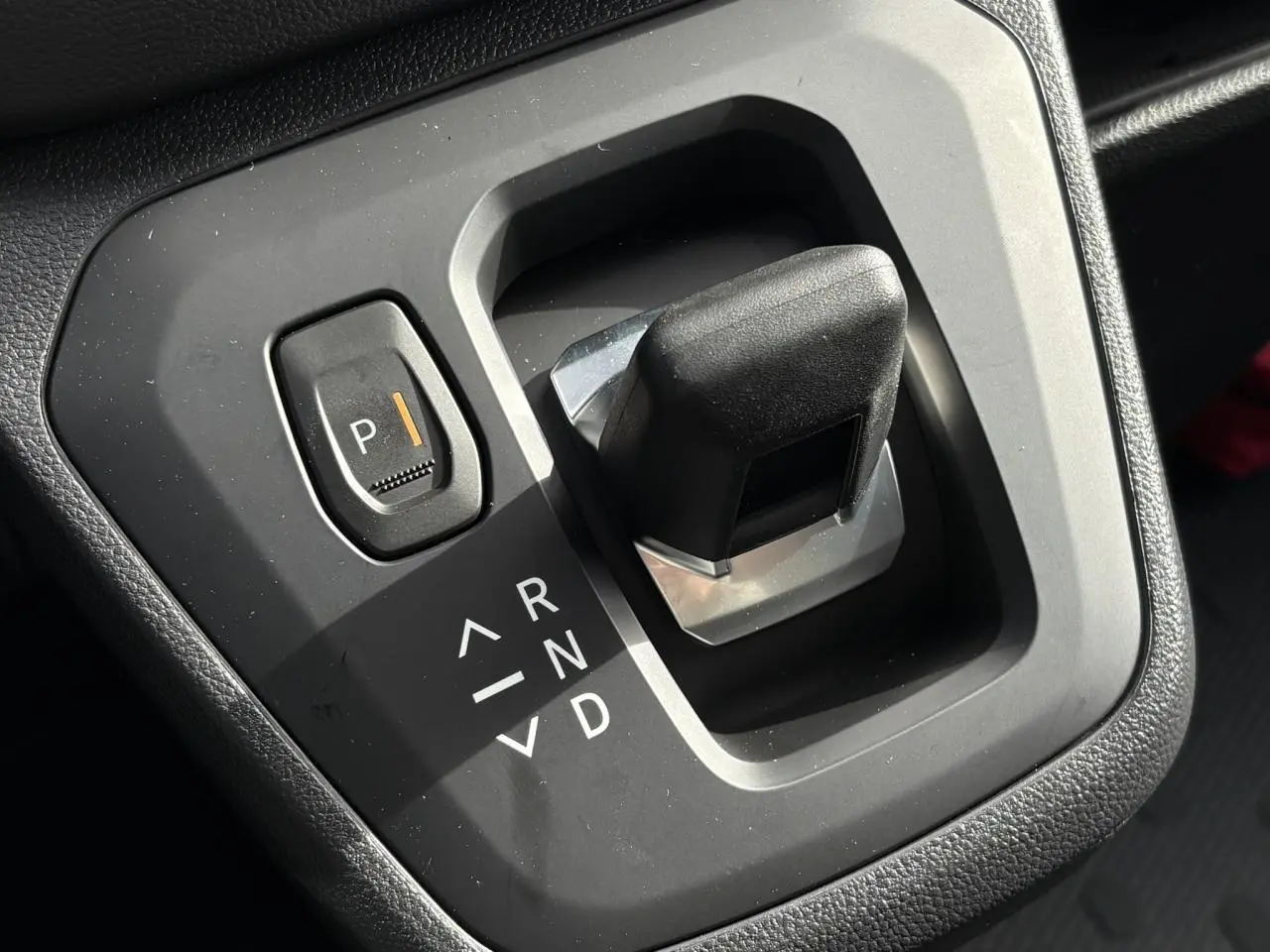 Gros plan sur la commande de boîte automatique noire du Renault Trafic Fourgon blanc, avec bouton parking éclairé.