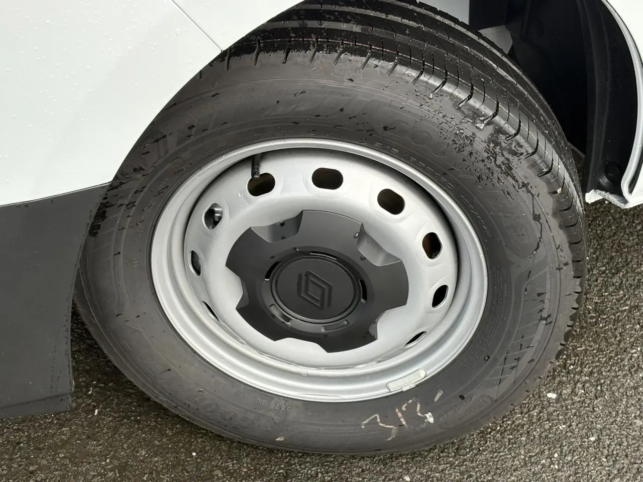 Gros plan sur la roue avant gauche du Renault Trafic Fourgon blanc glacier, avec jante acier et logo Renault central.