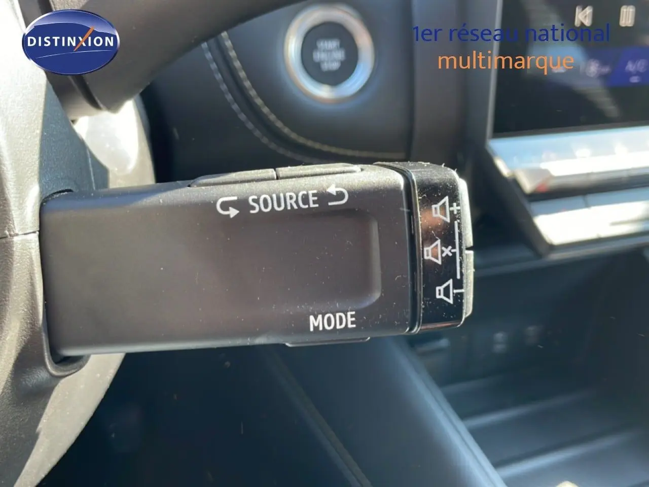 Gros plan sur la commande au volant de la Renault Symbioz 2025, avec bouton source et mode, intérieur noir.