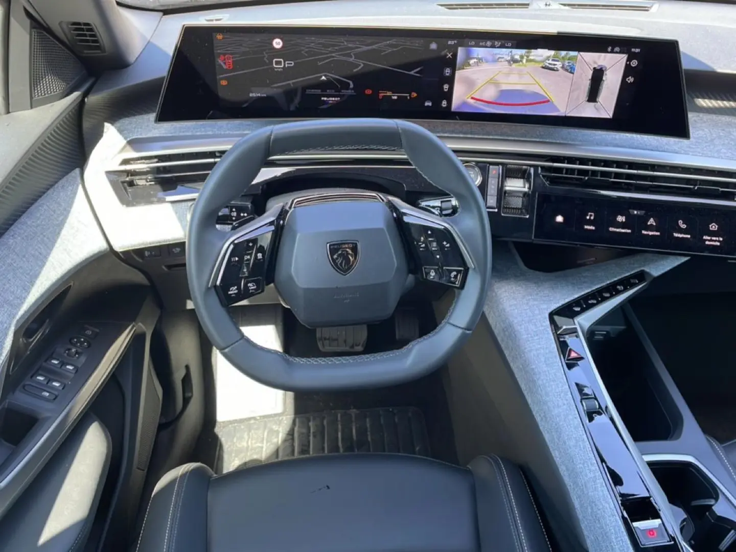 Vue intérieure du poste de conduite du Peugeot 5008 Hybrid 145 allure e-dcs6 2025, volant cuir et grand écran tactile panoramique.