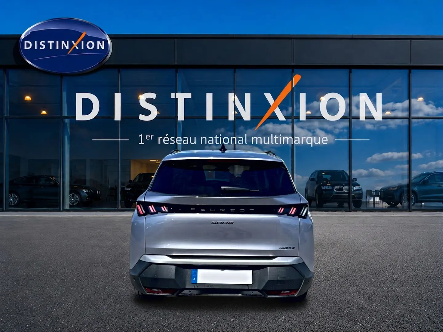 Vue arrière d’un Peugeot 5008 Hybrid 145 allure e-dcs6 gris artense, avec feux arrière LED et logo distinctif.