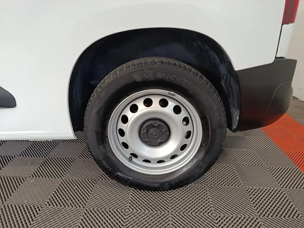 Gros plan sur la roue arrière droite d’un Citroën Berlingo blanc 2021 avec jante acier et pneu Michelin.